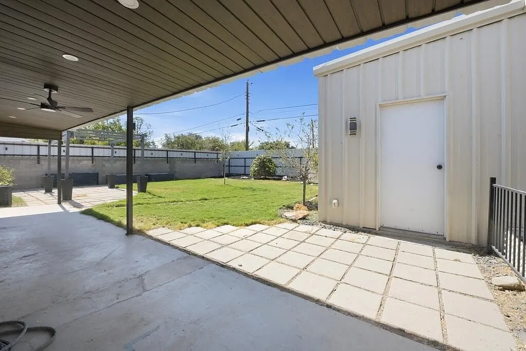 Detached steel shop building with a covered concrete patio leading to it